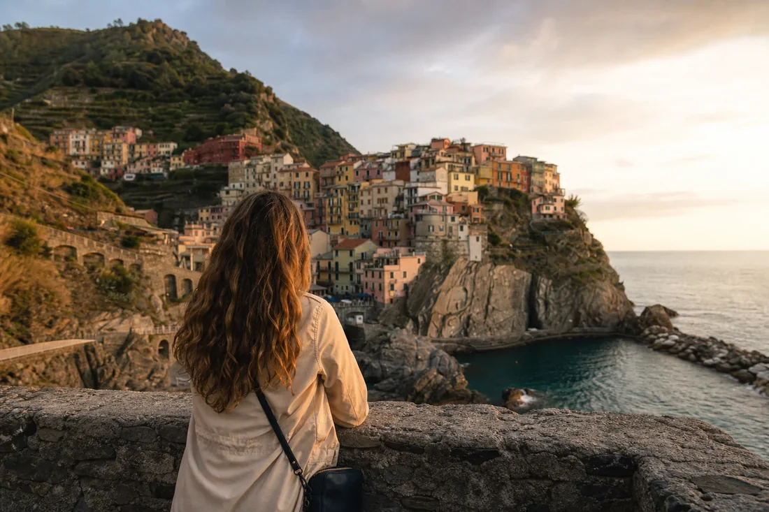 Traveler above a Mediterranean cliffside village, shown inside a mock Lightroom pane