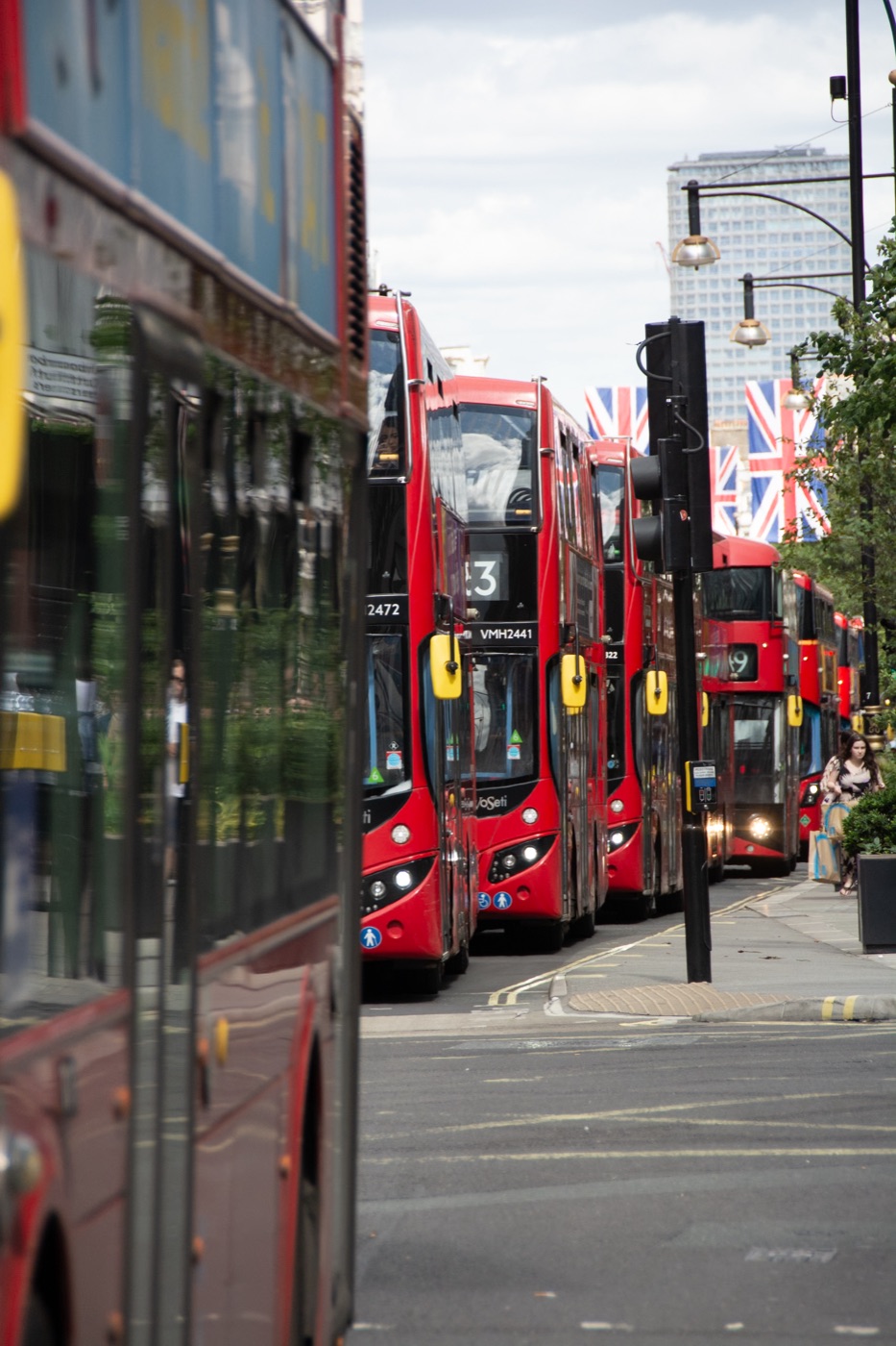 Corrected city street of red buses before the preset